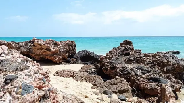 Lavafelsen an der Küste mit türkisem Meer