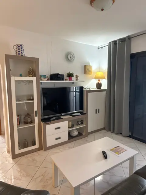 Wohnbereich mit Fernseher und Vitrine